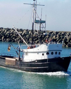 An Old Fishing Boat Is Near A Small Wooden Dock Near A White